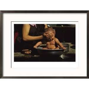  A Bhutanese Woman Bathes Her Baby in a Large Metal Bowl 