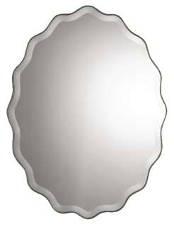 This ovalshaped wall mirror features a scalloped edge finished in 