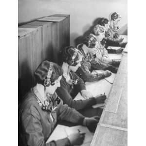 British Telephone Operators Wearing Headsets Working at Switchboard 